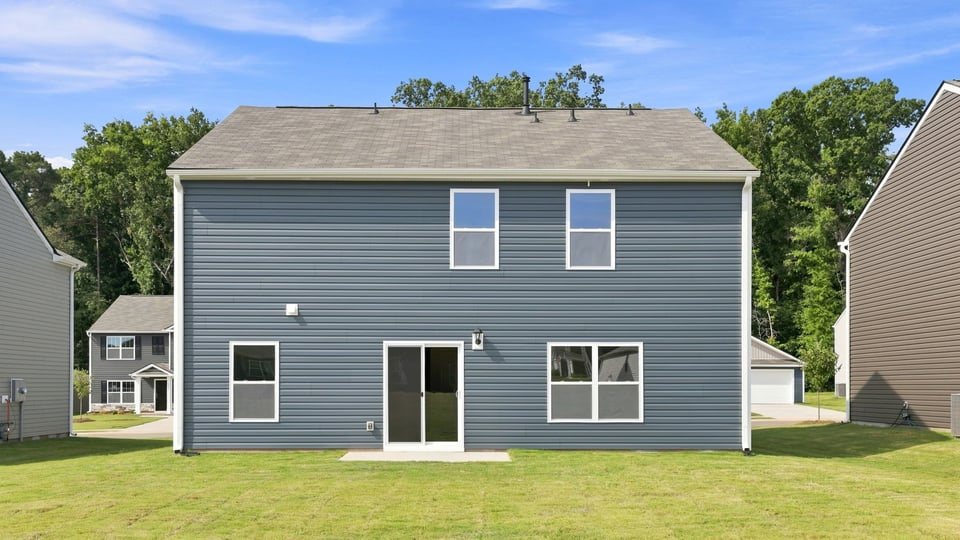 Back exterior of home with large backyard.