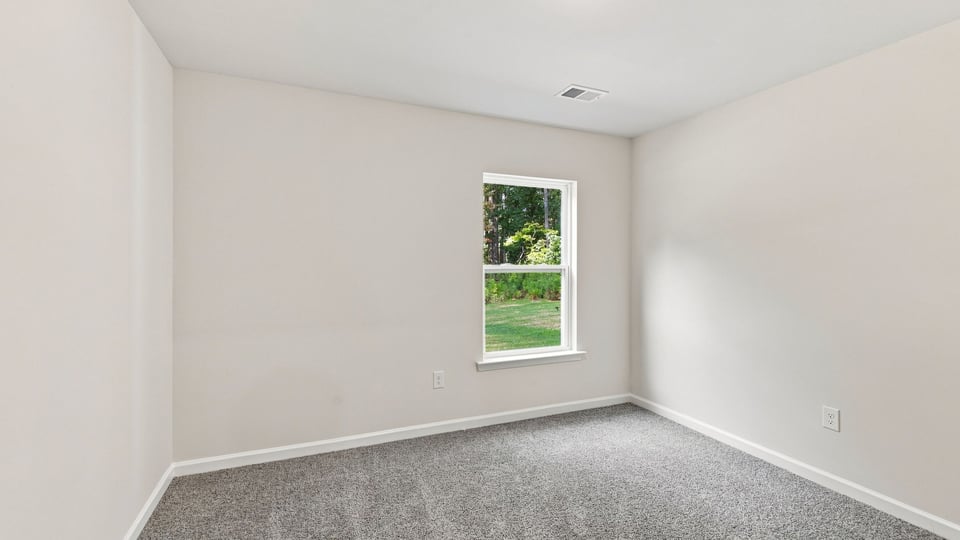 Bedroom with carpet and window.