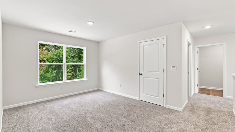 Bedroom with carpet and window.