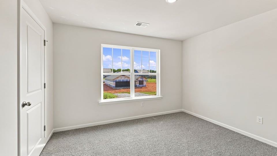 Bedroom with carpet and window.
