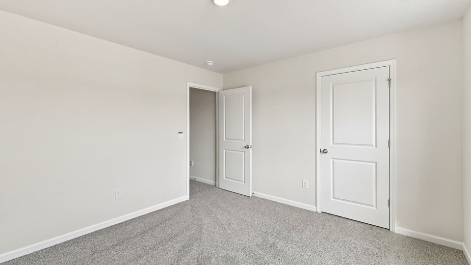Bedroom with carpet and window.