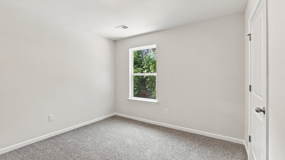 Bedroom with carpet and window.
