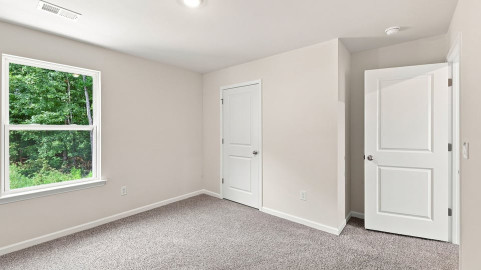Bedroom with carpet and window.