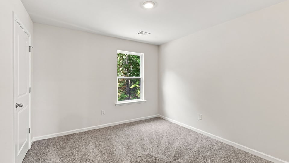 Bedroom with carpet and window.