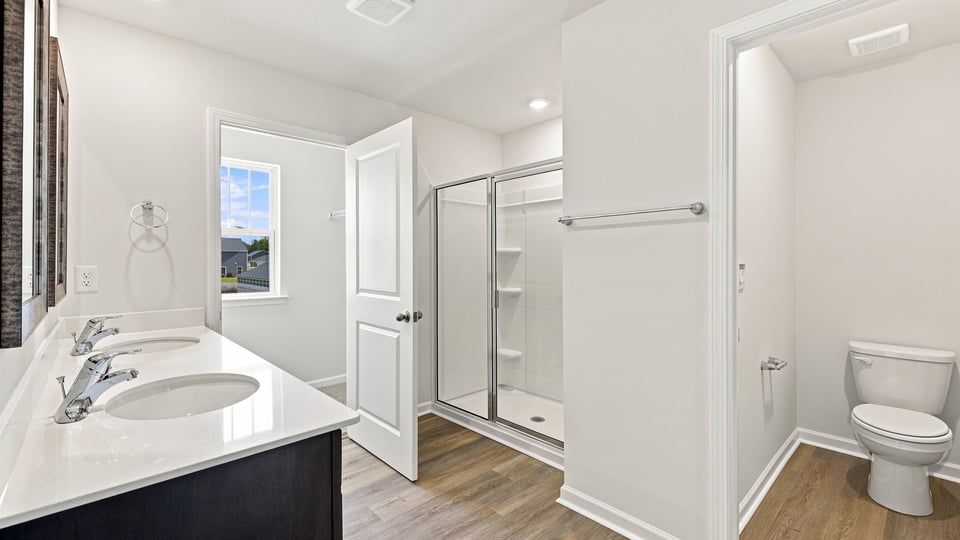 Bathroom with double vanity sink and walk in shower.