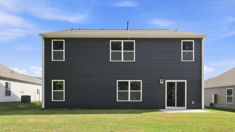 Back exterior of home with large backyard.