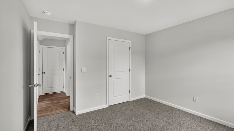 Bedroom with carpet and windows.