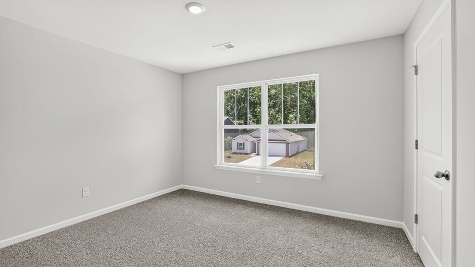 Bedroom with carpet and windows.