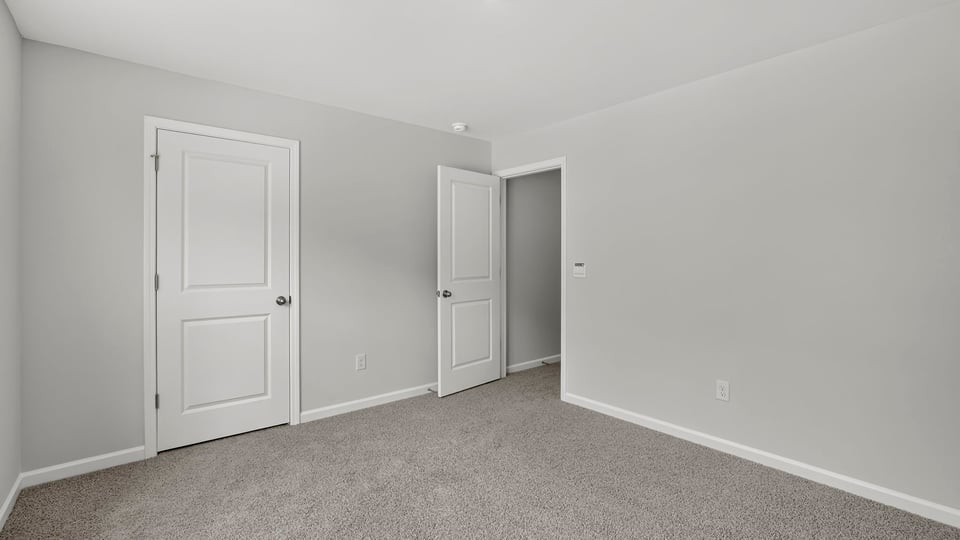 Bedroom with carpet and windows.