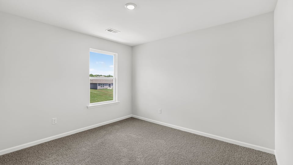 Bedroom with carpet and windows.
