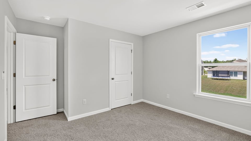 Bedroom with carpet and windows.