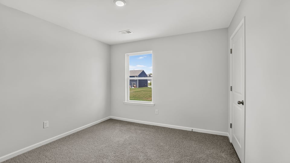 Bedroom with carpet and windows.