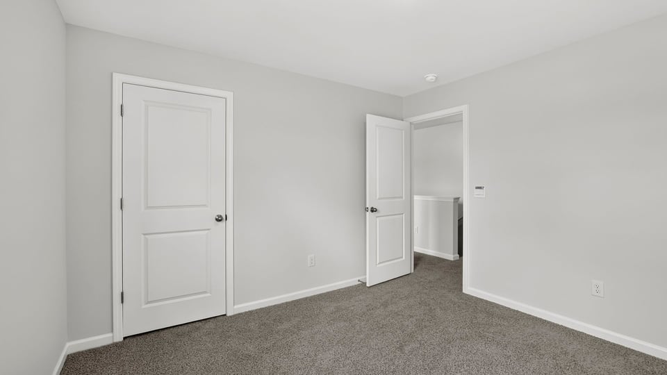 Bedroom with carpet and windows.