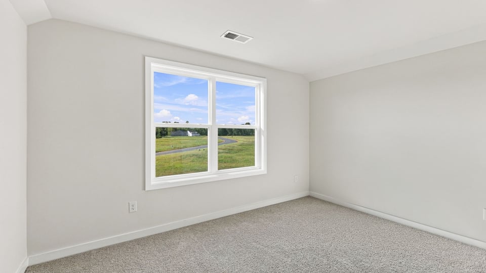 Bedroom with carpet and windows.