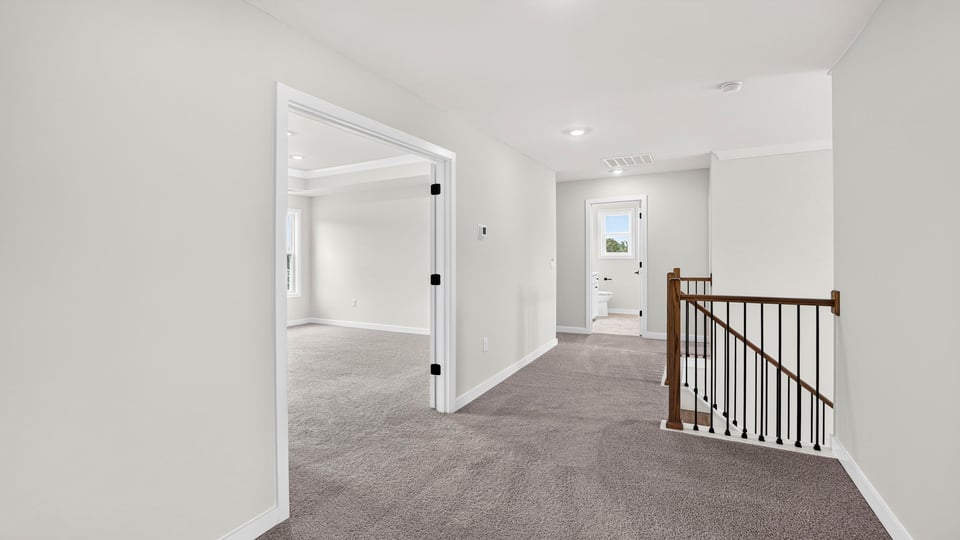 Loft area with carpet and window.