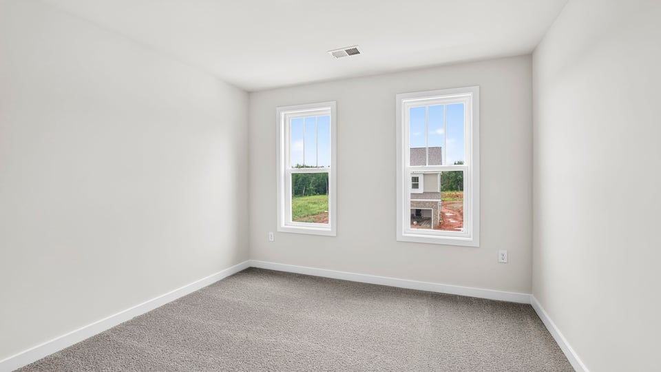 Bedroom with carpet and windows.