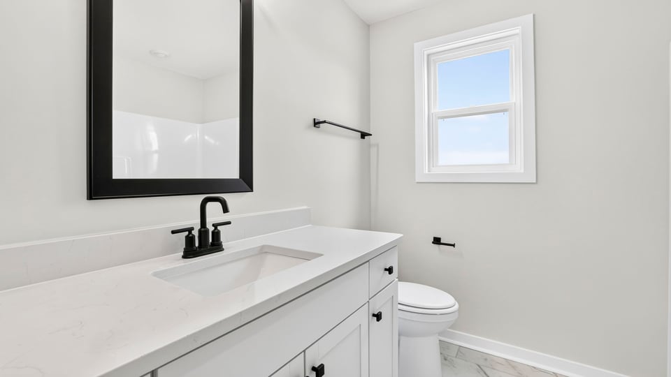 Bathroom with window and single vanity sink.