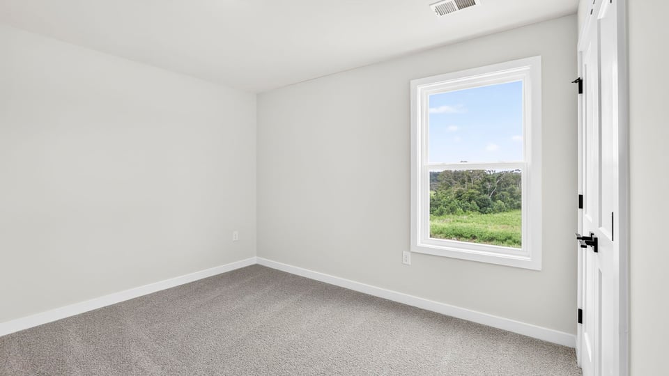 Bedroom with carpet and windows.