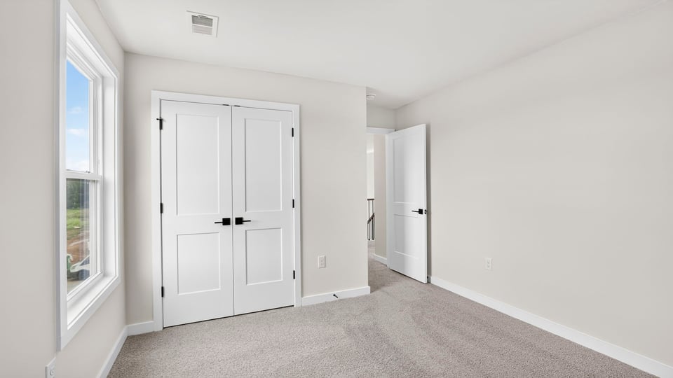 Bedroom with carpet and windows.