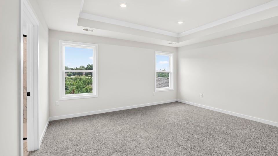 Bedroom with carpet and windows.