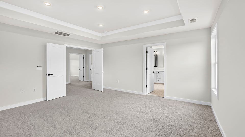 Bedroom with carpet and windows.