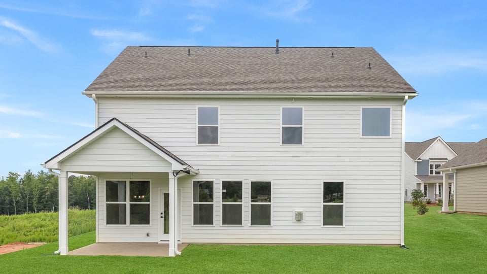 Back exterior of home with large backyard.