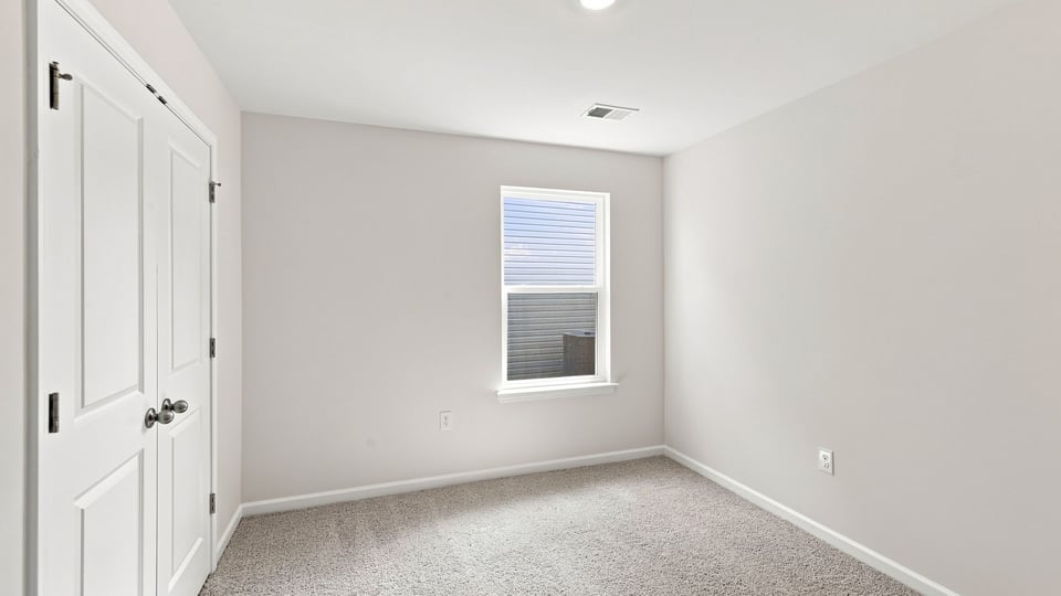 Bedroom with carpet and window.