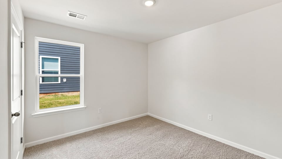 Bedroom with carpet and window.