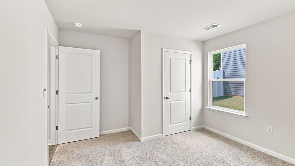 Bedroom with carpet and window.