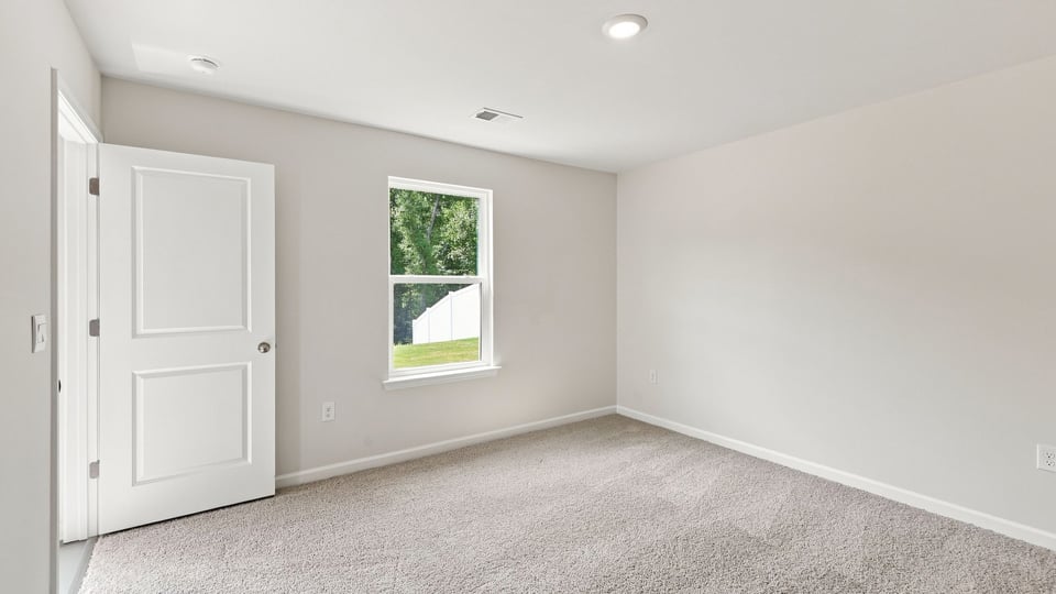 Bedroom with carpet and window.