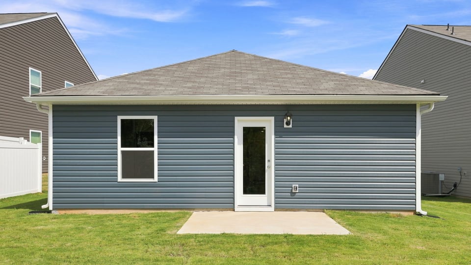 Back exterior of home with large backyard.