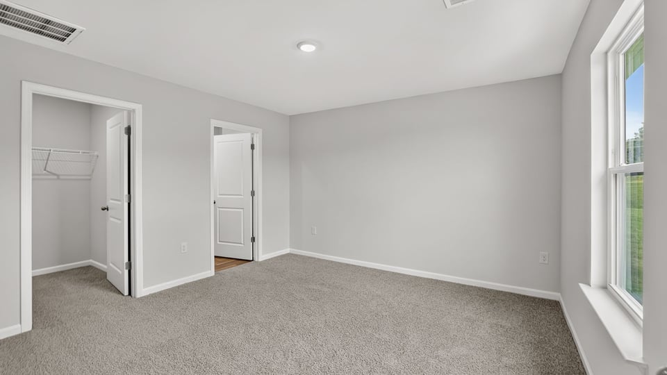 Bedroom with carpet and window.
