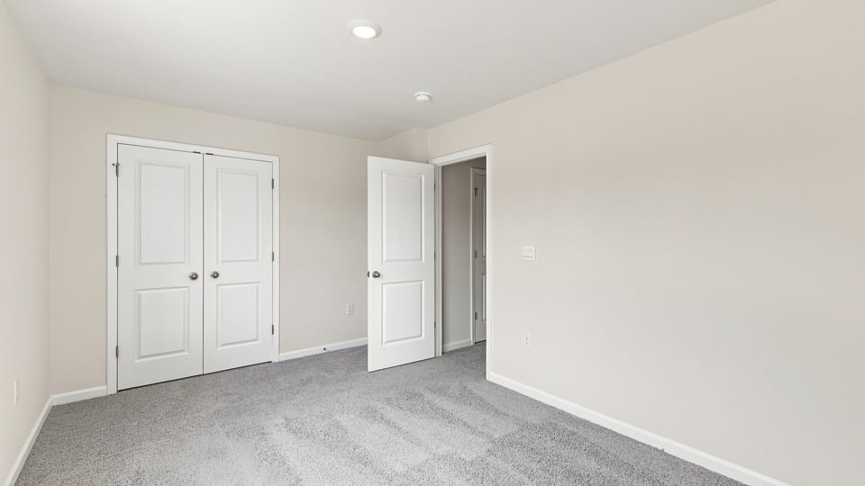 Bedroom with carpet and window.