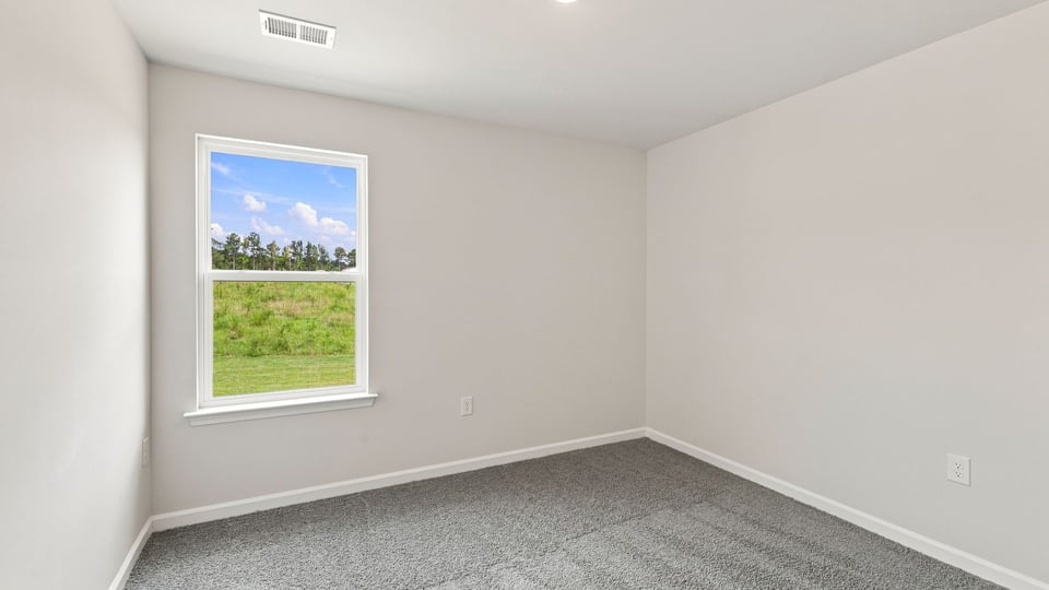 Bedroom with carpet and window.