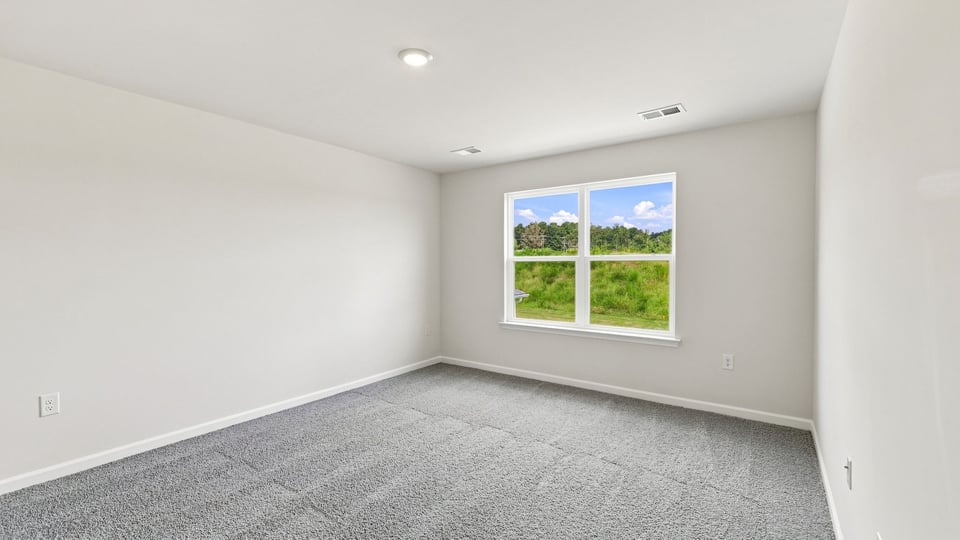 Bedroom with carpet and window.