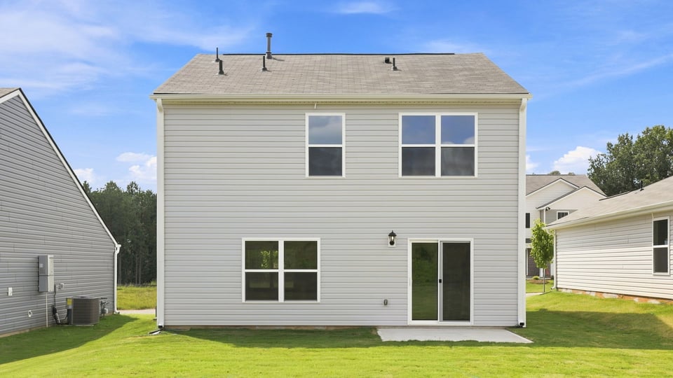 Back exterior of home with large backyard.