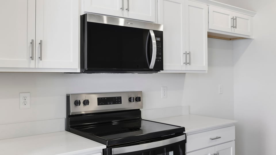 Kitchen and island with quartz countertops and stainless steel appliances.