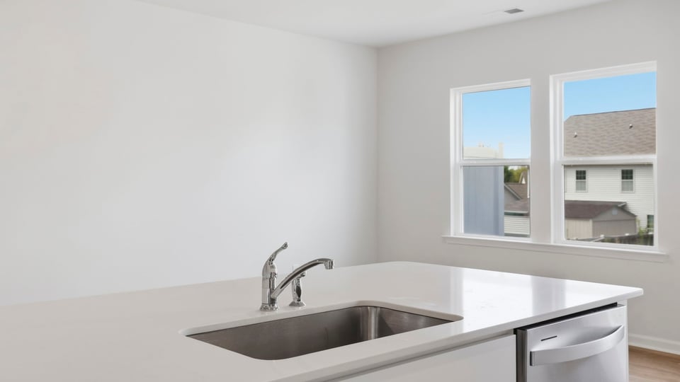 Kitchen and island with quartz countertops and stainless steel appliances.