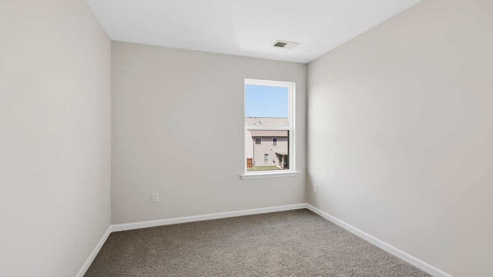Bedroom with carpet and window.