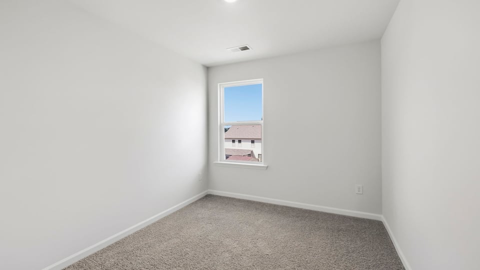 Bedroom with carpet and window.