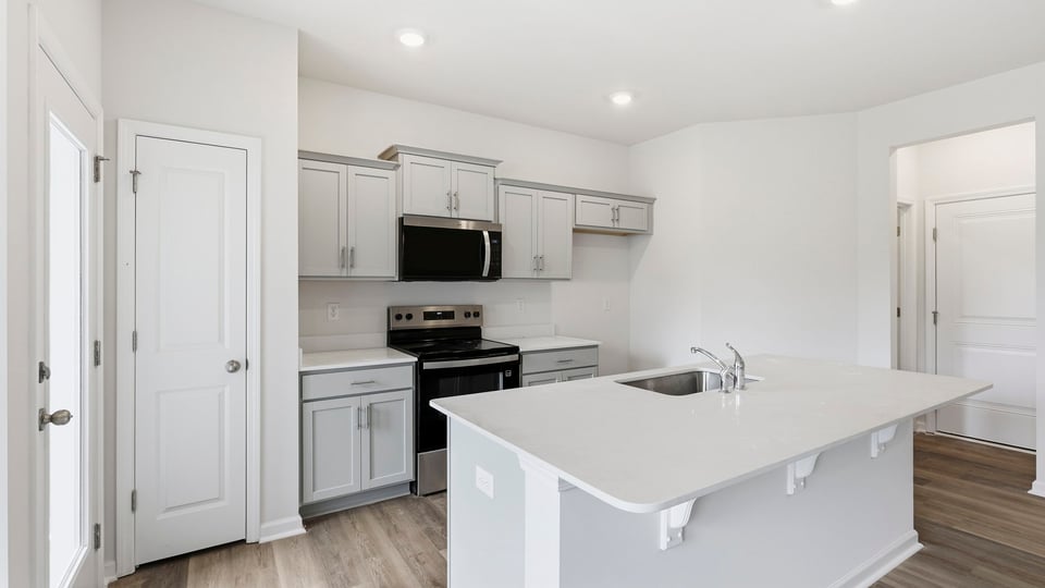 Kitchen and island with quartz countertops.