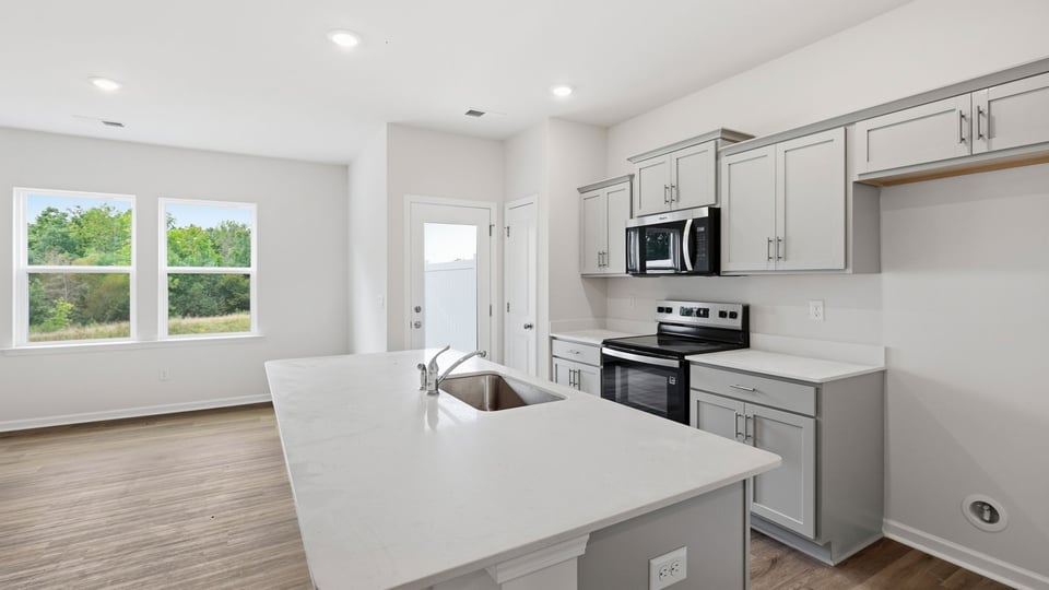 Kitchen and island with quartz countertops.