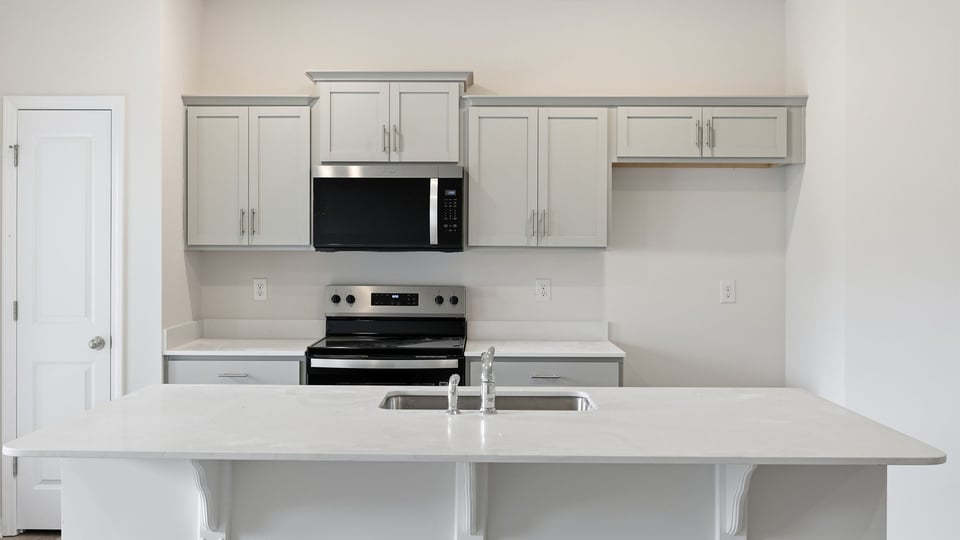 Kitchen and island with quartz countertops.