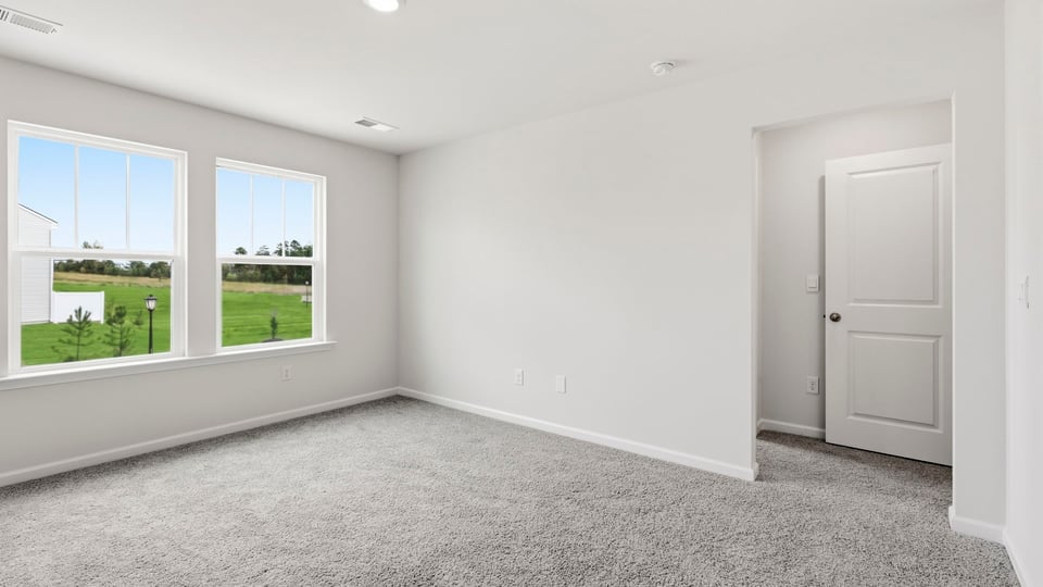 Bedroom with carpet and window.