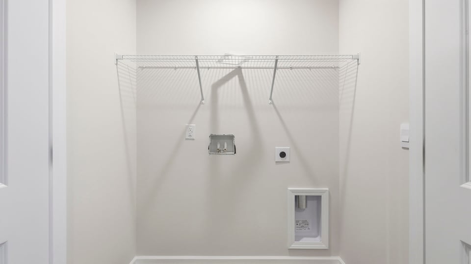 Laundry room with hanging storage racks.