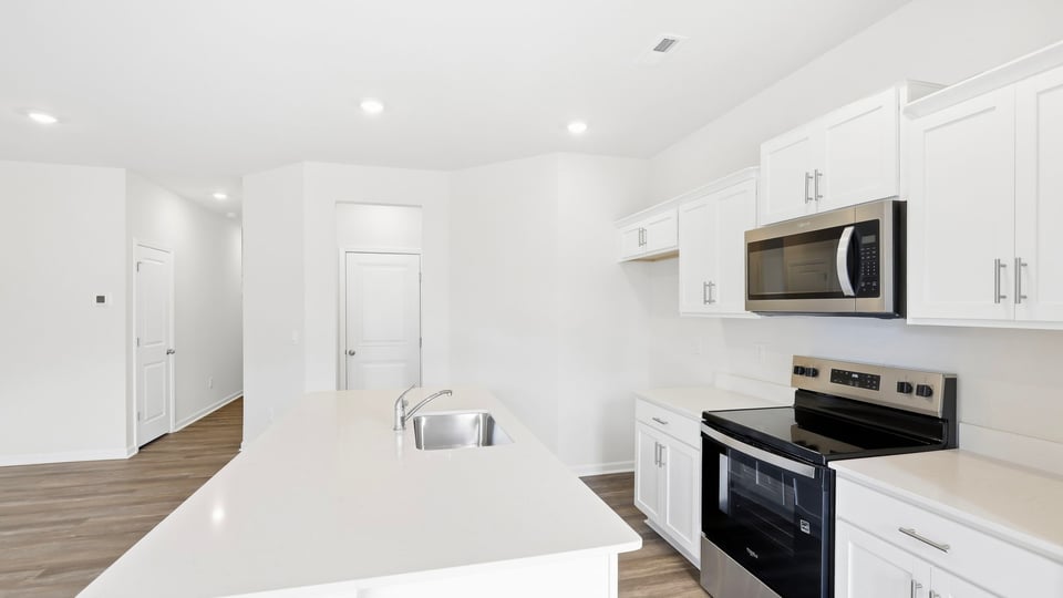 Kitchen and island with quartz countertops.
