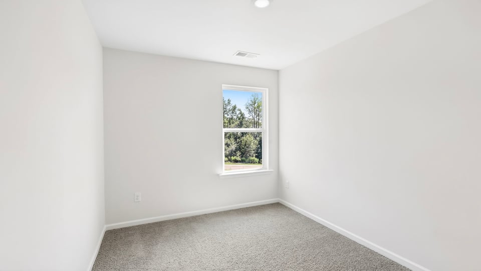 Bedroom with carpet and window.
