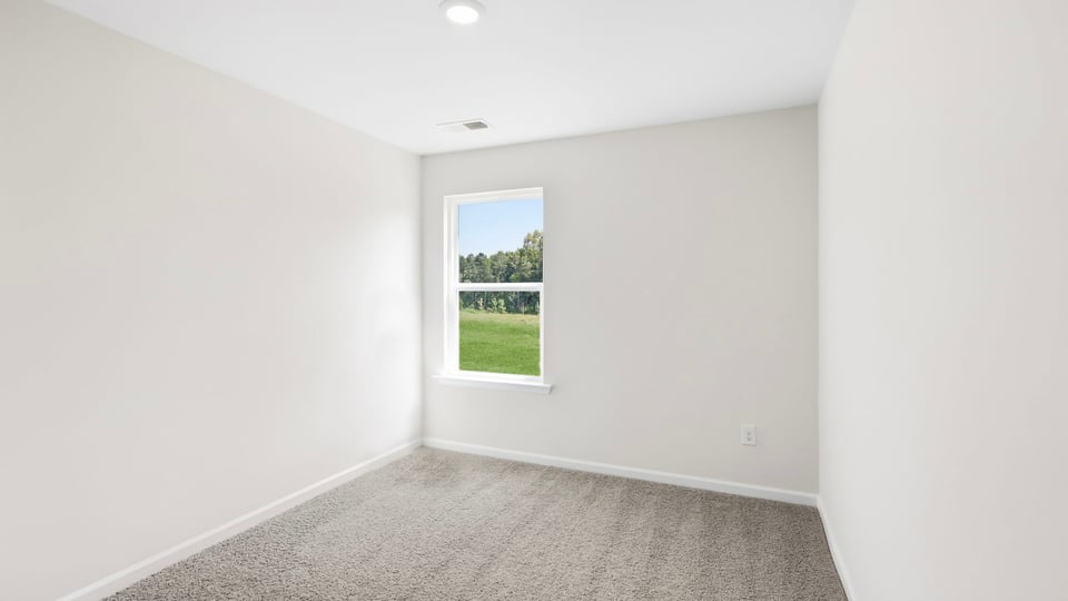 Bedroom with carpet and window.