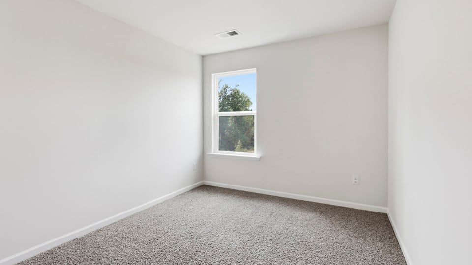 Bedroom with carpet and window.