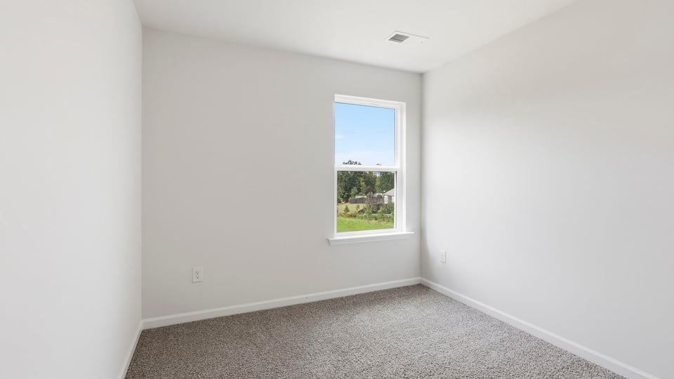 Bedroom with carpet and window.